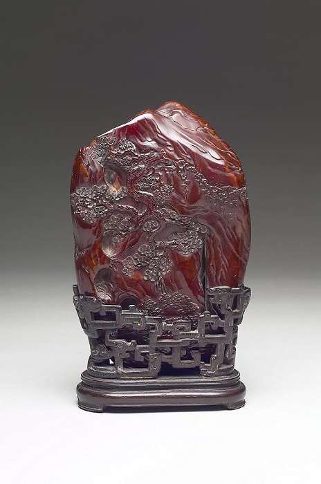 Opaque amber miniature mountain featuring the symbols of longevity, pine trees and deer