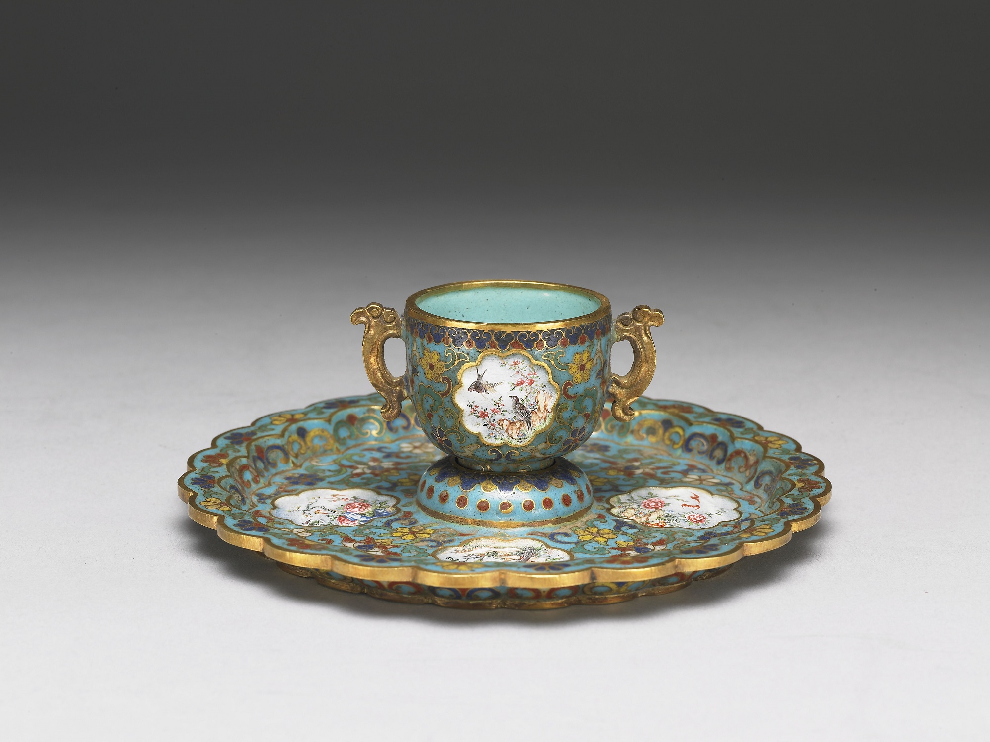 Gold cloisonné cup and saucer with painted enamel designs of flowers and birds