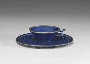 Single-handled cup and sucer decorated with gold tracing on cobalt blue glaze