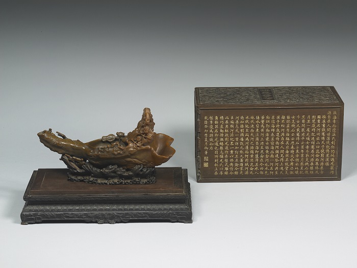 Rhinoceros horn carved with depiction of figures seated atop a raft